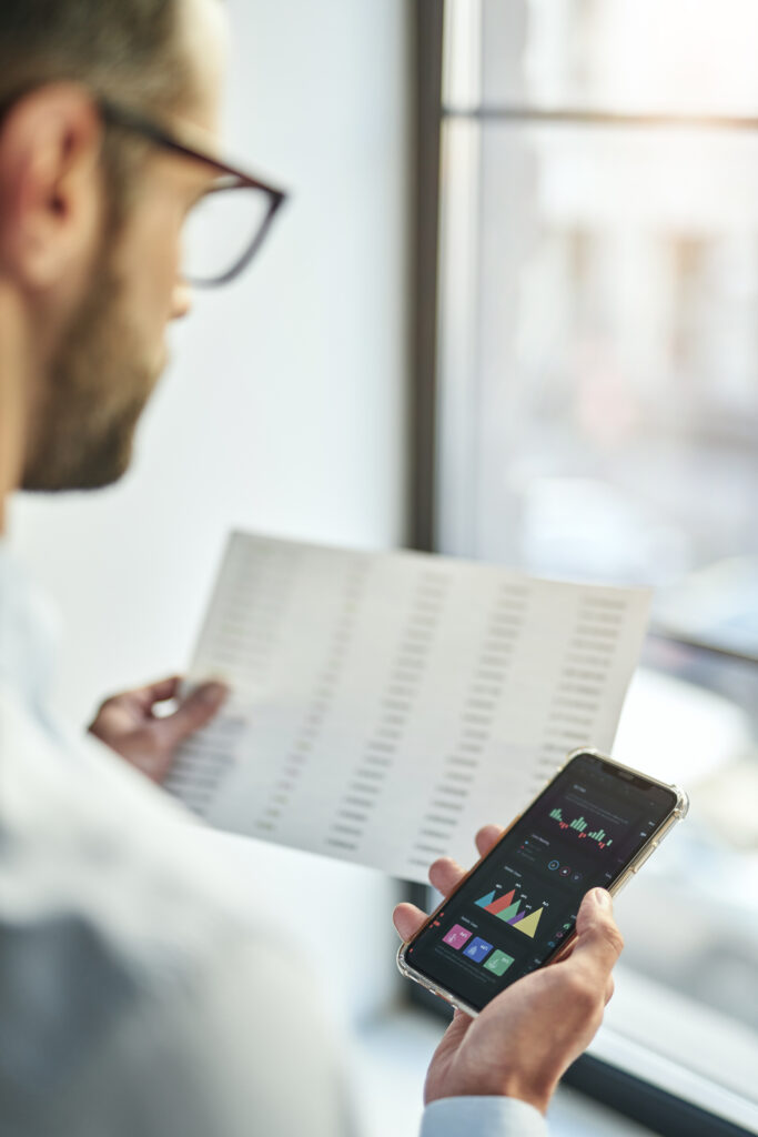 Um funcionário de uma empresa trabalhando com seu smartphone e um dos apps instalados fazendo a coleta de dados